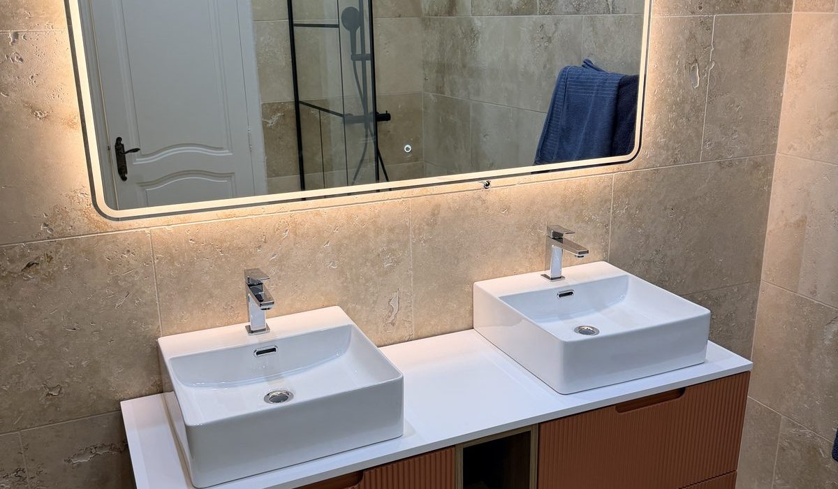 Salle de bain rénovée par CVC Plomberie Marseille — double vasque, miroir LED, carrelage travertin