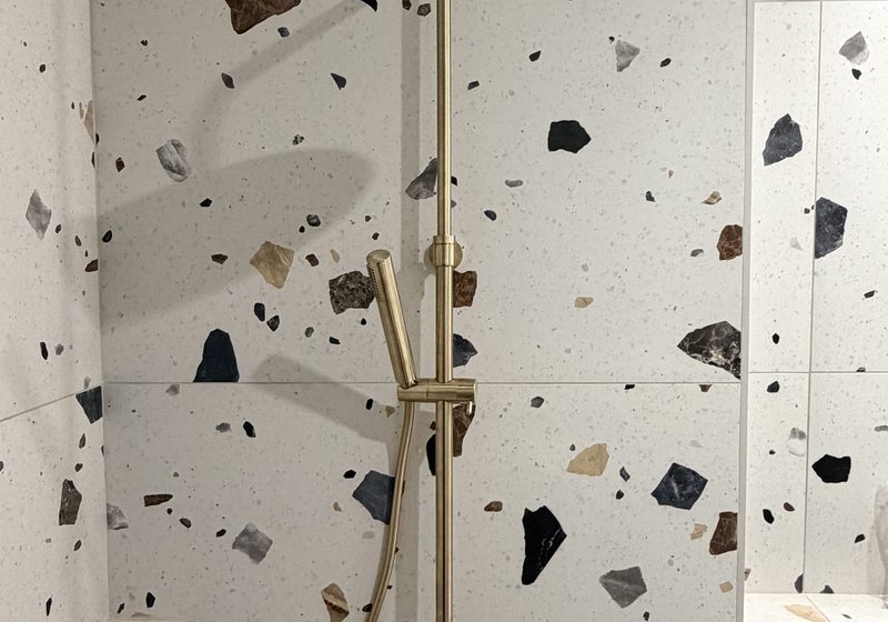 Salle de bain terrazzo robinetterie dorée — rénovation CVC Marseille